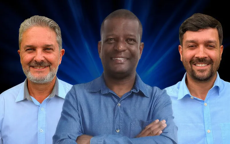 Roger Geraldo Silva, de braços cruzados, entre os dois apresentadores do Soluções Cast